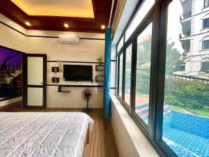 a bedroom with a bed and a large window at Bean Villa Tam Đảo in Tam Ðảo