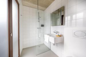 uma casa de banho branca com um lavatório e um chuveiro em BANKS Antwerp em Antuérpia mais 37 fotografias