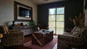 an old trunk in a living room with chairs and a window at Casa Eike in El Calafate