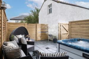 a backyard with a hot tub and a fence at Camellia House Crest Apartment in Abersoch
