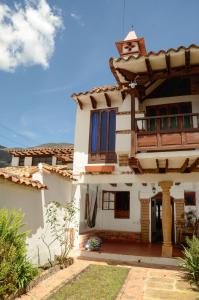 a large white house with blue windows at La CASITA BOUTIQUE VILLA DE LEYVA in Villa de Leyva