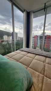a bedroom with a large window with a view of a city at The Park Loft in Cochabamba +39 photos