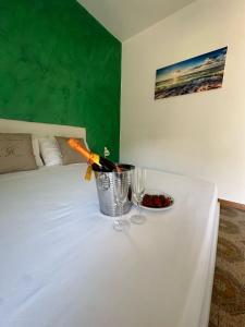 a table with a bottle of wine and glasses on a bed at Greta Apartment Tropea in Tropea +48 photos