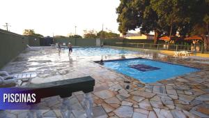 a swimming pool with a man standing in the water at Espaço para você in Ribeirão Preto