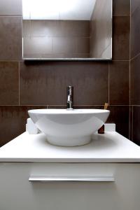 a white sink in a bathroom with a mirror at Grand Central Market Suites By VALENCIAFLATS EU in Valencia