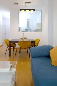 a living room with a blue couch and yellow chairs at Grand Central Market Suites By VALENCIAFLATS EU in Valencia