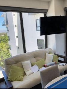 a white couch in a room with a large window at Puerto Vallarta Centro de convenciones Aeropuerto in Puerto Vallarta