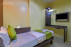 a bedroom with a bed and a flat screen tv at Hotel Gemini in Mumbai