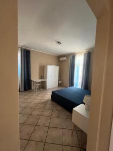 una camera con letto blu e pavimento piastrellato di Residence Quedar a Melfi