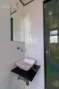 a white bathroom with a sink and a mirror at Hotel Gemini in Mumbai +40 photos