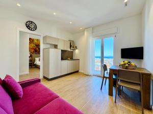 a living room with a purple couch and a table at YourHome - Il Pino Rooms & Apartment in Meta