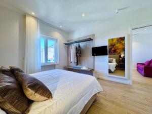 a bedroom with a large bed and a tv at YourHome - Il Pino Rooms & Apartment in Meta