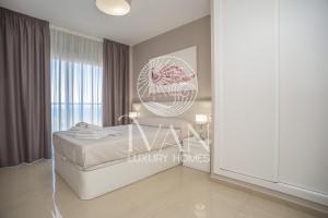 ein Schlafzimmer mit einem weißen Bett und einem Fenster in der Unterkunft Casa Noe Ivan Luxury Homes 5ªPlta Norte 1ªLinea in Oropesa del Mar + 27 Fotos