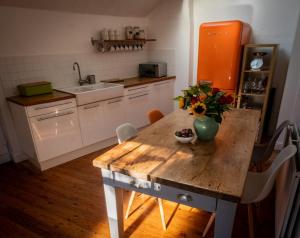a kitchen with a wooden table with a vase of flowers on it at Wirksworth Townhouse - full of character in Wirksworth