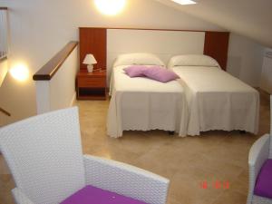 1 dormitorio con 2 camas, mesa y sillas en Silenzi Holiday Home en Fertilia