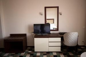 a room with a desk with a television and a mirror at Oriental grand Plaza in Madinat Al Ashir min Ramadan