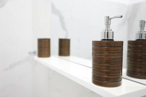a row of brown bottles on a white shelf at Clara Apartment in Parghelia +16 photos