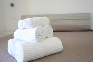 a stack of white towels stacked on a bed at Clara Apartment in Parghelia
