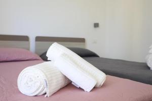 two white towels are stacked on a bed at Clara Apartment in Parghelia