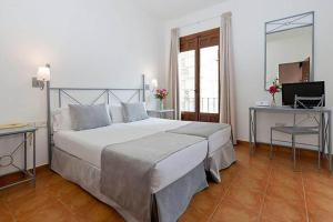 Postel nebo postele na pokoji v ubytování Sercotel Toledo Imperial