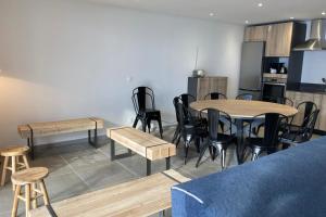 a room with tables and chairs and a kitchen at Triplex in Albiez-Montrond - 4 Bedrooms in Albiez-Montrond