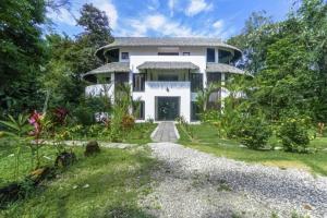 a large white house with a yard at Makara Suite Penthouse in Uvita