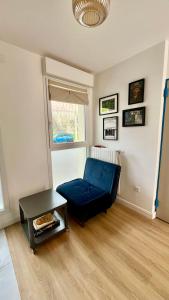 a living room with a blue couch and a table at Maison 88 Malakoff in Malakoff