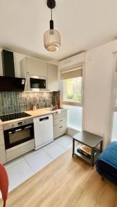 a kitchen with white appliances and a table in a room at Maison 88 Malakoff in Malakoff +36 photos
