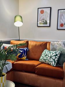 eine Couch mit Kissen darauf in einem Wohnzimmer in der Unterkunft Trendy 3 Bedrooms-Free Parking-Sleeps 8 in Kent + 17 Fotos