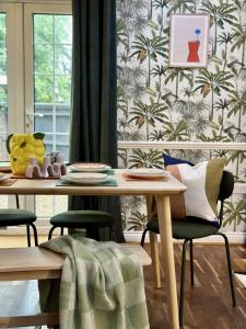 a dining room with a table and chairs and a wall at Spacious 3 Bedrooms-Free Parking-Sleeps 8 in Kent