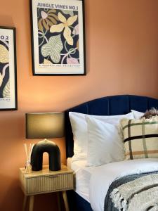 ein Schlafzimmer mit einem Bett und einem Nachttisch neben einem Bett in der Unterkunft Trendy 3 Bedrooms-Free Parking-Sleeps 8 in Kent