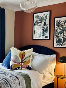 Schlafzimmer mit orangefarbenen Wänden und einem Bett mit Kissen in der Unterkunft Modern 3 Bedrooms-Free Parking-Sleeps 8 in Kent