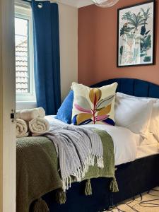 a bedroom with a bed with a blue headboard at Spacious 3 Bedrooms-Free Parking-Sleeps 8 in Kent