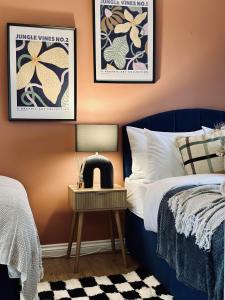 a bedroom with a blue bed and a nightstand with a side table at Spacious 3 Bedrooms-Free Parking-Sleeps 8 in Kent