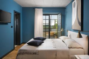a bedroom with a large bed with blue walls at Luxury Villa Covri in Brtonigla +24 photos