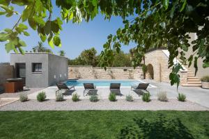 a swimming pool with chairs and a yard at Luxury Villa Covri in Brtonigla