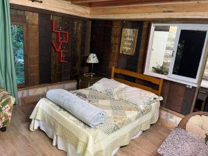 a bedroom with a bed in a wooden room at Choupana das Araucárias in Sapiranga