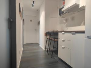 a small kitchen with white cabinets and a hallway at CconfortHotels Sea&Cruise Side Apartment in Bari