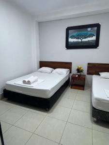a bedroom with two beds and a picture on the wall at IGUANA HAUS IQUITOS in Iquitos +141 photos