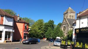 a city street with cars parked in front of a church at Easton's Little Secret in Bristol