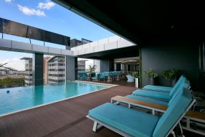 a patio with blue lounge chairs and a swimming pool at Hotel 430 in Gaborone