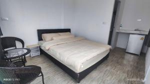 a bedroom with a bed and a table and a chair at ภูโอบตะวันรีสอร์ต - Phu Oab Tawan Resort in Nan