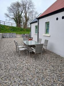 un patio con tavolo e sedie di fronte a una casa di St Kevins Cottage a Hollywood
