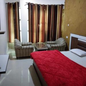Una habitación de hotel con una cama y dos sillas. en Hotel Kings, en Pathankot 1 foto más