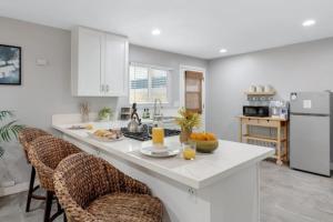 a kitchen with a counter and two bar chairs at Studio 2 Pool Spa Min to Downtown Freeways Beaches in San Diego