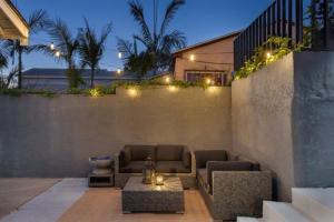 a patio with a couch and lights on a wall at Studio 2 Pool Spa Min to Downtown Freeways Beaches in San Diego