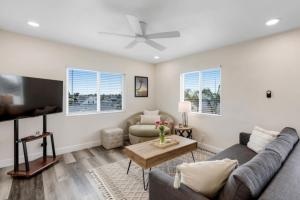 Una sala de estar con un sofá y un televisor. en Bridge Pool Spa Min to Downtown Freeways Beaches, en San Diego