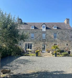 a large stone building with a yard in front of it at Ar Maen Gite et Chambres d'hotes in Lanvollon