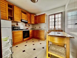a kitchen with wooden cabinets and a table in it at holidaycasa Leone - Con piscina stabilimento balneare e posto auto in Sperlonga +13 photos