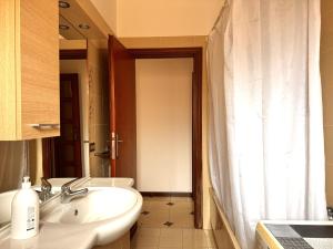 a bathroom with a sink and a shower curtain at holidaycasa Leone - Con piscina stabilimento balneare e posto auto in Sperlonga